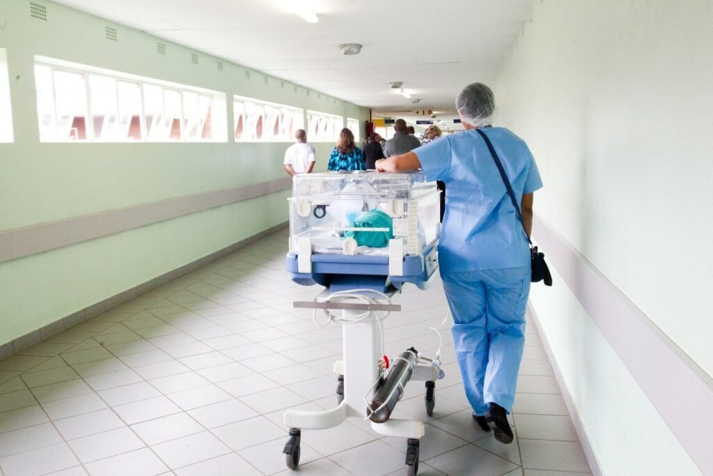 Operatore sanitario in una corsia di ospedale durante attività assistenziale